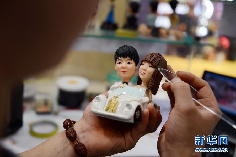 Fu Xinxi, a folk artist in north China's Shandong province, makes "lover dough figurines" on Feb. 9, 2014. His dough figurines are made on the basis of lovers' photos and are popular among them before the Valentine's Day. Dough figurines are made from steamed wheat flours, glutinous rice flour, and glycerin. (Xinhua/Sun Xiaozheng)