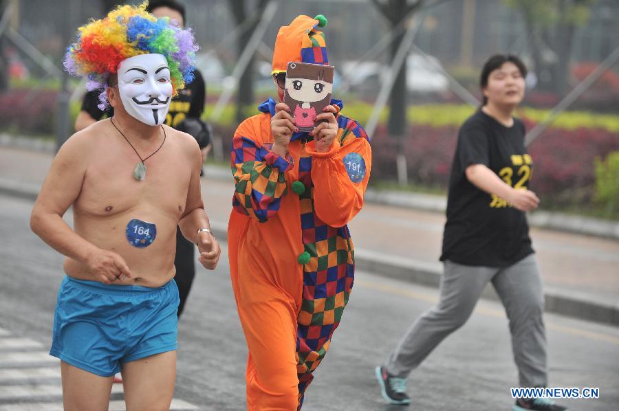 People wearing clown costume take part in a running race in Nanjing, capital of east China's Jiangsu Province, March 29, 2014. A special race was held here on Saturday, in which participants wore only underwear so as to advocate the 2014 Earth Hour event and promote the concept of green lifestyle. (Xinhua/Shen Peng) 