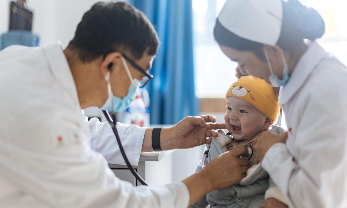 Doctor Liu Jianshi (left) performs auscultation screening on a child in Yuepuhu county on May 13, 2023.Photo:Li Hao/GT