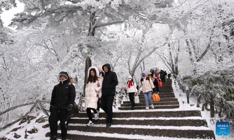 Tourists enjoy the snow scenery at the Huangshan Mountain scenic area in Huangshan City, east China's Anhui Province, Dec. 16, 2023. The scenic area witnessed the first snowfall in this winter recently. (Xinhua/Zhou Mu)