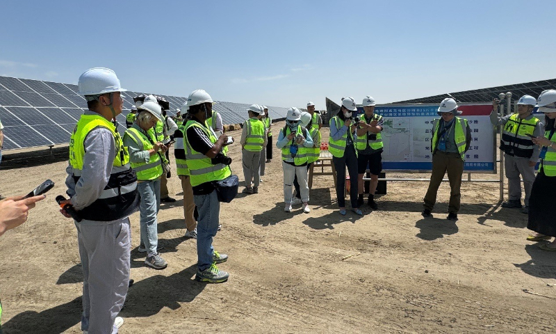 Journalists visit the 250,000-kilowatt photovoltaic industrial park in Xayar county. The operator of the project explains how Xinjiang's photovoltaic projects integrate environmental management and agricultural cultivation. Photo: Chen Qingrui/GT