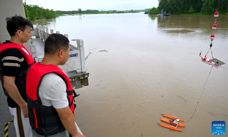 Staff members monitor the flood water at a hydrological station in Funan County of Fuyang, east China's Anhui Province, July 14, 2024. Measures including monitoring the flood water, inspecting embankment and ensuring flood-control materials have been taken by the authorities of Funan County of Fuyang, east China's Anhui Province, to control the 