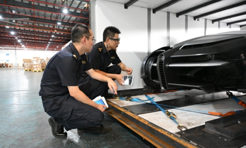 Staffers from the Shanghai branch of the General Administration of Customs check a Japanese-made electric concept three-wheeler for customs clearance. The three-wheeler is set to make its China debut at the 7th China International Import Expo (CIIE), which will kick off on November 5, 2024 in Shanghai. Photo: General Administration of Customs