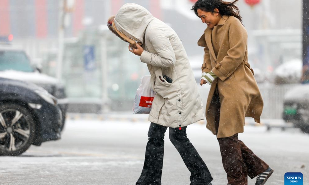 People walk in snow in Urumqi, northwest China's Xinjiang Uygur Autonomous Region, Nov. 14, 2024. A cold front has ushered in significant drop in temperature and snowfall across Xinjiang. (Photo: Xinhua)