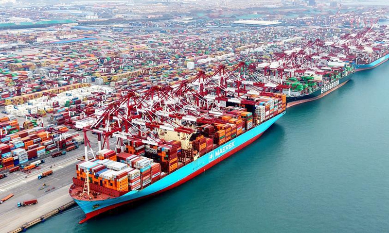 This aerial drone photo taken on Dec. 27, 2025 shows cargo ships loading and unloading containers at Qingdao Port in east China's Shandong Province. (Photo by Yu Fangping/Xinhua)