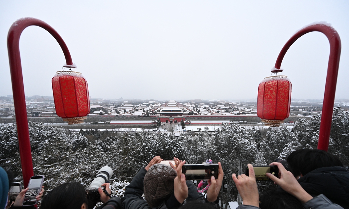 Tourists at Jingshan Park in Beijing brave the snow to capture panoramic photos of the snow-covered Palace Museum or known as the Forbidden City on January 18, 2026. Photo: Chen Tao/GT