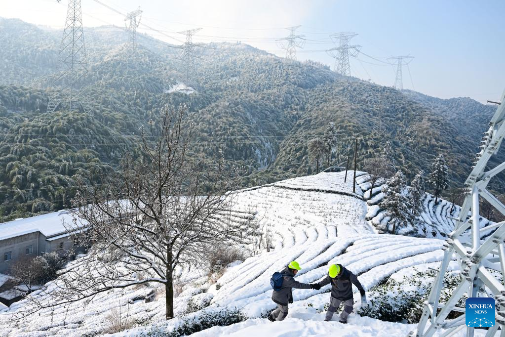 Maintenance workers conduct deicing operation to ensure power supply in E China's Jinzhai County