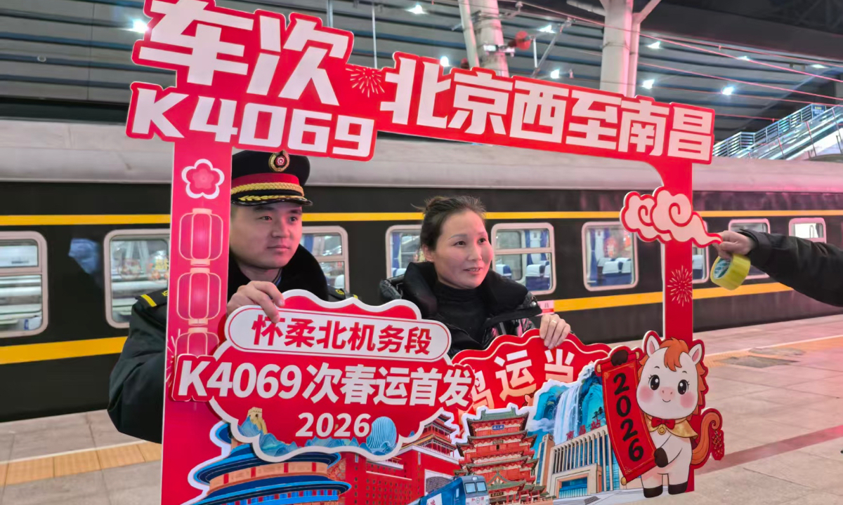 The conductor of Train K4069 poses for a photo with a passenger before the train departs from Beijing West Railway Station for Nanchang in East China’s Jiangxi Province on February 2, 2026. Photo: Zhang Yiyi/GT