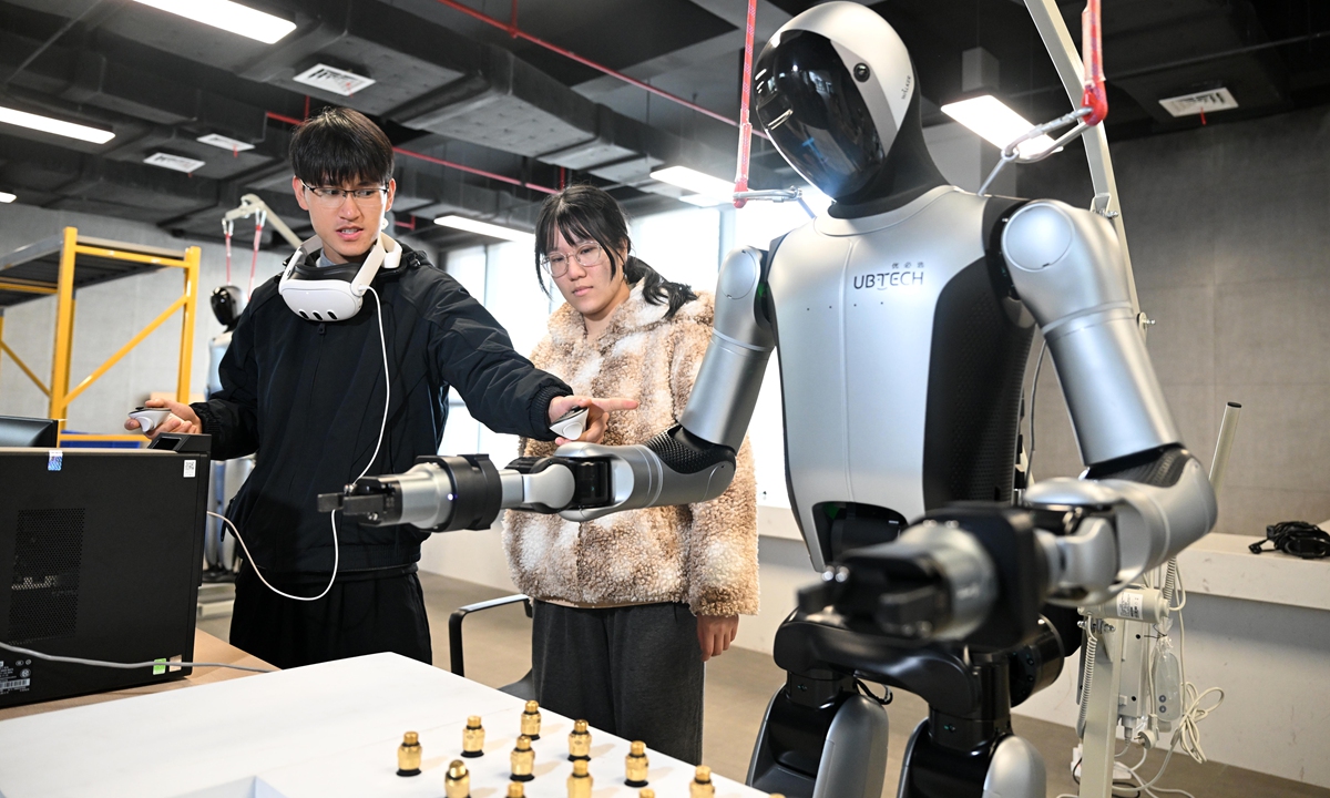 Wu Dongbo (left) and his new colleague discuss the key points of practicing operational movements for industrial humanoid robots at the Liuzhou Robot Industrial Park in Guangxi Zhuang Autonomous Region on February 11, 2026. Photo: Courtesy of Li Hanchi