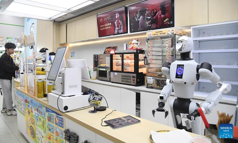 A humanoid robot works at a convenience store in Haidian District of Beijing, capital of China, April 22, 2026. An embodied large model robot has recently been deployed in a convenience store in Haidian District to provide regular service. The robot is responsible for greeting customers, answering product inquiries, providing promotion information, and delivering goods. (Xinhua/Ren Chao)