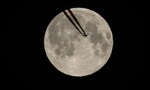 Plane flies against backdrop of full moon in Paris