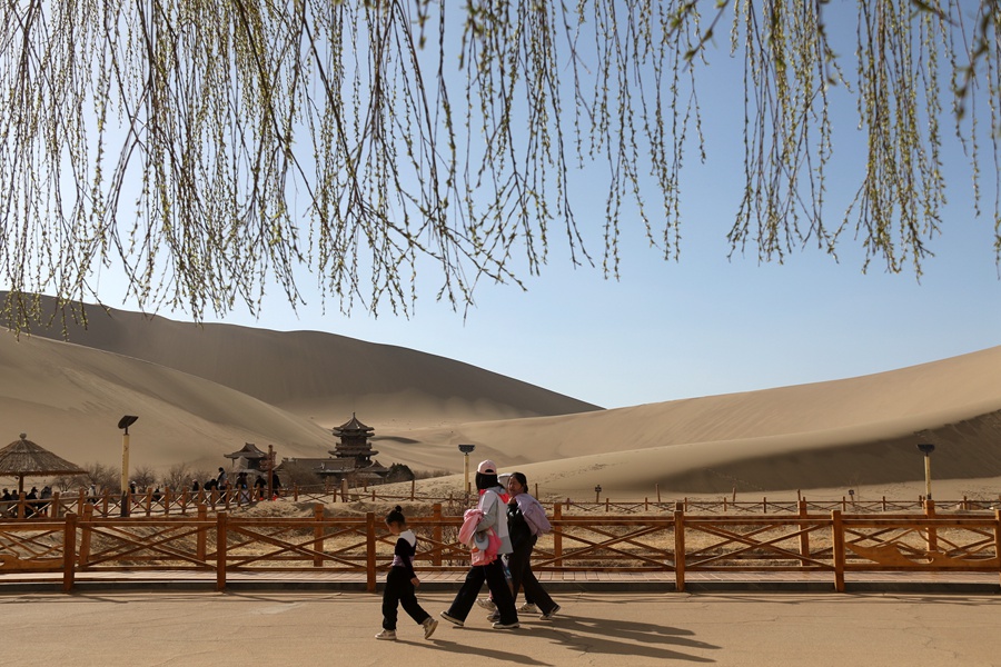 Tourists enjoy picturesque spring views of desert in Dunhuang, NW China's Gansu