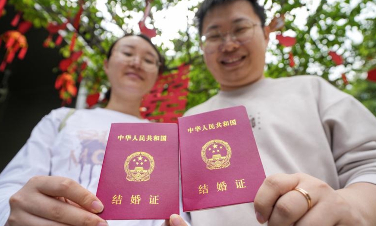 A young couple poses for photos with their marriage certificates at a marriage registration office in Nanjing, East China's Jiangsu Province on May 10, 2025. Photo: Xinhua