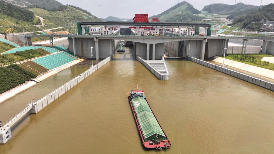 An aerial drone photo taken on Aug. 12, 2026 shows a trial vessel driving out of a navigation lock on the Pinglu Canal in south China's Guangxi Zhuang Autonomous Region. (Xinhua/Zhou Hua)