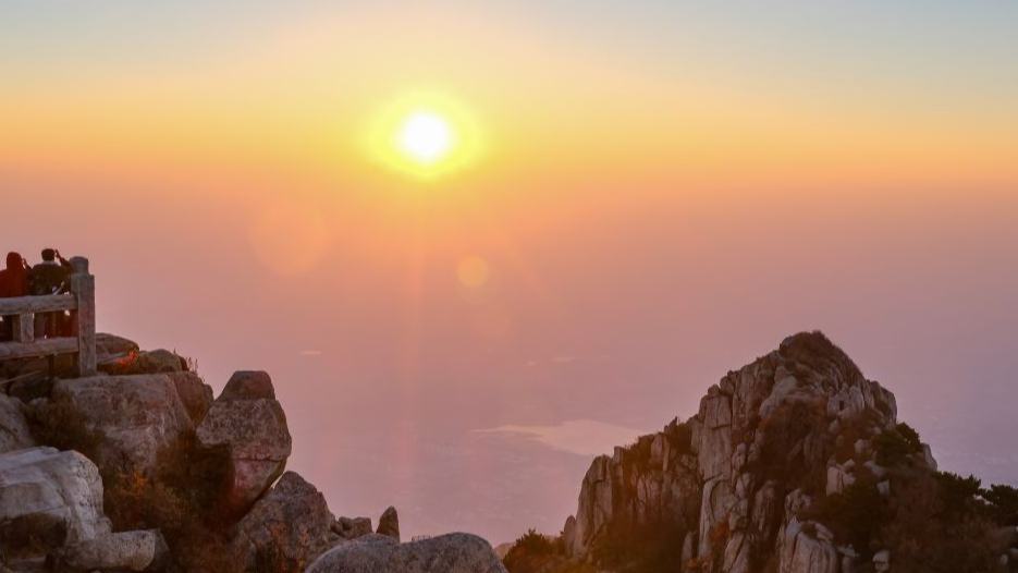 Tourists enjoy sunrise at Mount Tai in China's Shandong