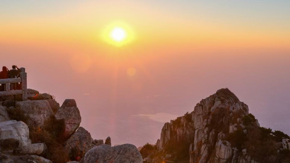 Tourists enjoy sunrise at Mount Tai in China's Shandong
