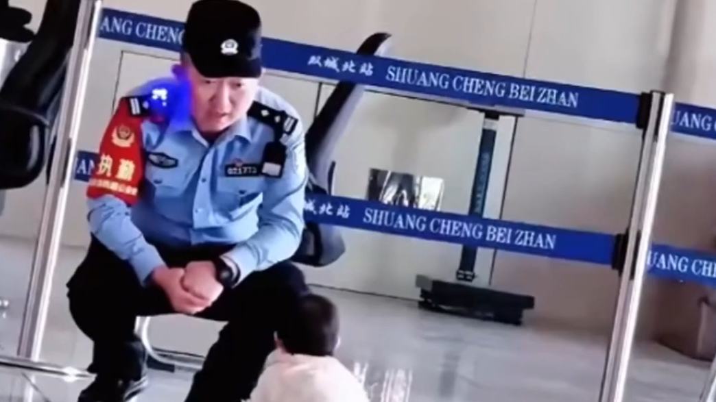 So sweet! Baby crawls over for a hug with police officer at Harbin railway station