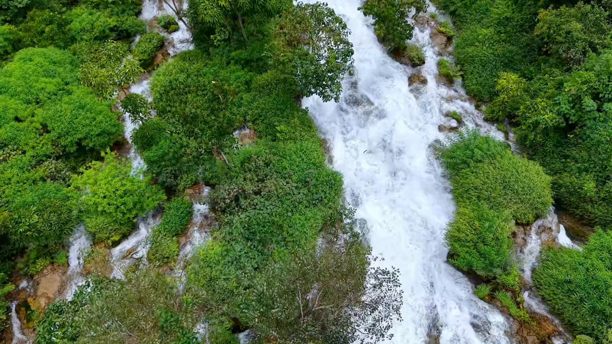 Waterfall flows down lush mountainside in SW China's Guizhou