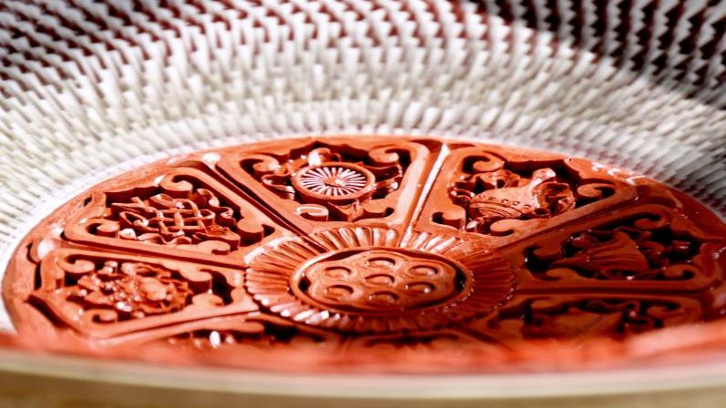 Inheritor of carved lacquer art presents craft on porcelain body