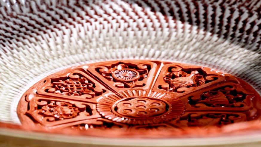 Inheritor of carved lacquer art presents craft on porcelain body