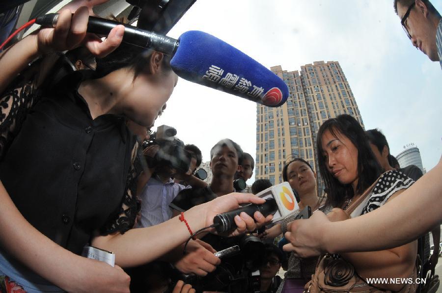 Tang Hui, mother of a young rape victim who sued a local authority for putting her into a labor camp, receives interview after the final ruling outside The Hunan Provincial People's High Court in Changsha, capital of central China's Hunan Province, July 15, 2013. The Hunan Provincial People's High Court on Monday ordered the Yongzhou municipal re-education through labor commission to pay Tang Hui 2,941 yuan (478 U.S. dollars) in compensation for infringing upon her personal freedom and causing mental damages. The 40-year-old mother appealed to the high court in April after the Yongzhou Intermediate People's Court denied her request for an apology and compensation from the re-education through labor commission. Tang was put into the labor camp after she publicly petitioned for harsher punishments for those found guilty of raping her daughter and forcing her into prostitution. (Xinhua/Long Hongtao) 