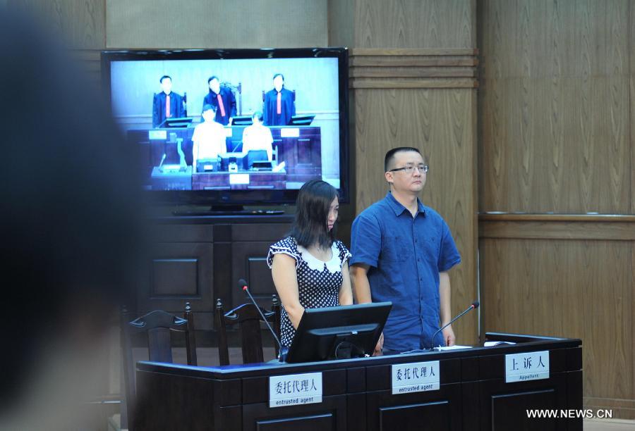 Tang Hui (L), mother of a young rape victim who sued a local authority for putting her into a labor camp, attends the court hearing in The Hunan Provincial People's High Court in Changsha, capital of central China's Hunan Province, July 15, 2013. The Hunan Provincial People's High Court on Monday ordered the Yongzhou municipal re-education through labor commission to pay Tang Hui 2,941 yuan (478 U.S. dollars) in compensation for infringing upon her personal freedom and causing mental damages. The 40-year-old mother appealed to the high court in April after the Yongzhou Intermediate People's Court denied her request for an apology and compensation from the re-education through labor commission. Tang was put into the labor camp after she publicly petitioned for harsher punishments for those found guilty of raping her daughter and forcing her into prostitution. (Xinhua/Long Hongtao) 