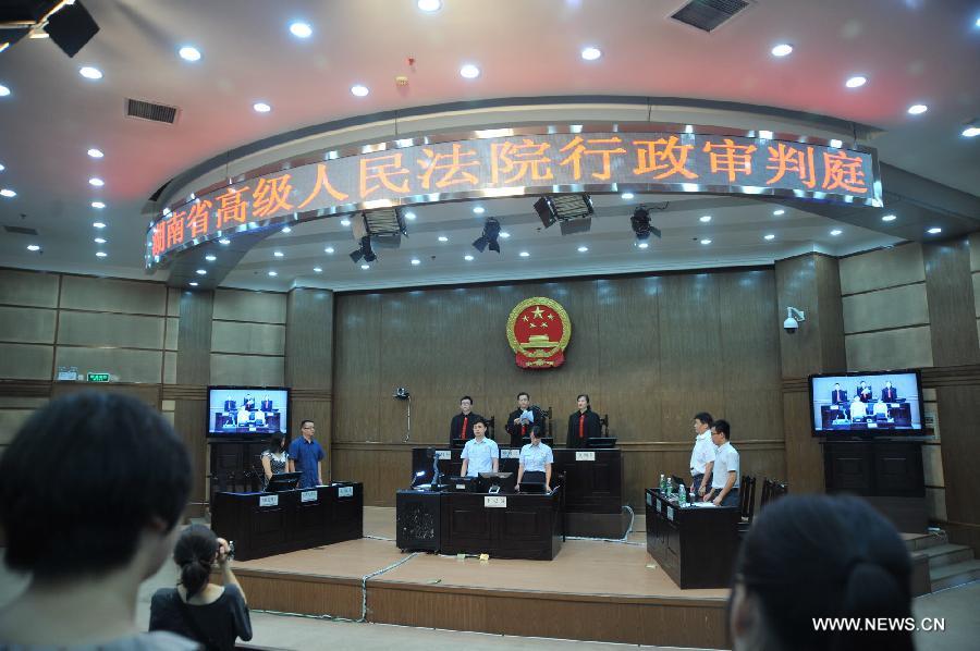 Photo taken on July 15, 2013 shows the judge reading the final ruling in the The Hunan Provincial People's High Court in Changsha, capital of central China's Hunan Province. The Hunan Provincial People's High Court on Monday ordered the Yongzhou municipal re-education through labor commission to pay Tang Hui 2,941 yuan (478 U.S. dollars) in compensation for infringing upon her personal freedom and causing mental damages. The 40-year-old mother appealed to the high court in April after the Yongzhou Intermediate People's Court denied her request for an apology and compensation from the re-education through labor commission. Tang was put into the labor camp after she publicly petitioned for harsher punishments for those found guilty of raping her daughter and forcing her into prostitution. (Xinhua/Long Hongtao) 