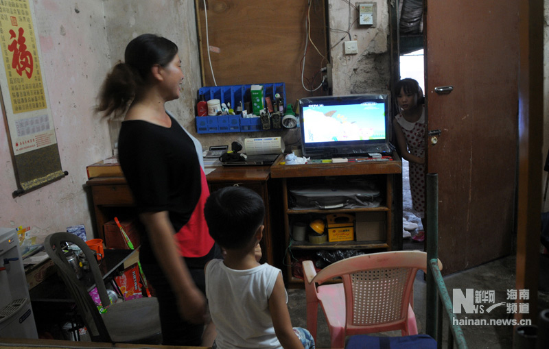 Cai Shaoye and her son watch TV at home. TV signals already cover all of Sansha Island.(Xinhua/Yu Tao)