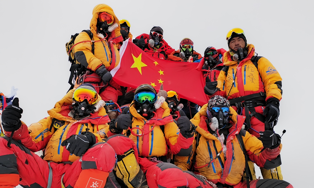 Thirteen Chinese scientists display the Chinese national flag on the summit of Mount Qomolangma after reaching the summit on May 23, 2023. After that, they are expected to complete important scientific tasks such as collecting snow and ice samples from the summit. This is the first time that China's Everest expedition has reached an altitude above 8,000 meters since 2022. Photo: Xinhua