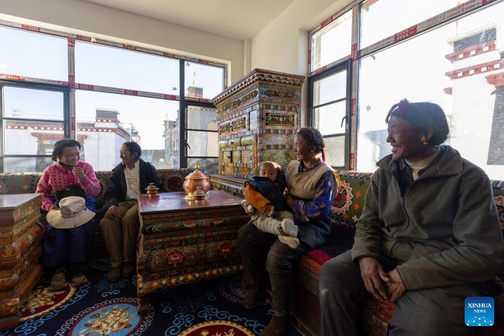24 اکتوبر 2025، جنوب مغربی چین کے خوداختیار علاقے شی زانگ کے شہر شی گازے کے گاؤں گیابوگ میں اہلِ خانہ نئے گھر میں مہمانوں کے ساتھ ۔ (شنہوا/جیانگ فان)